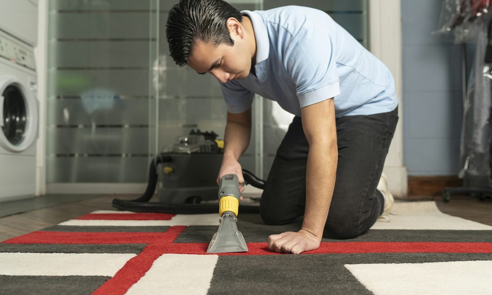 Laundry worker cleaning carpet with special equipment